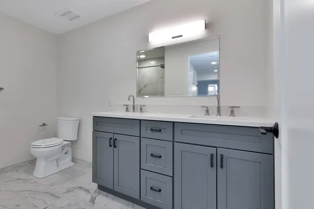 a bathroom with a toilet sink and mirror