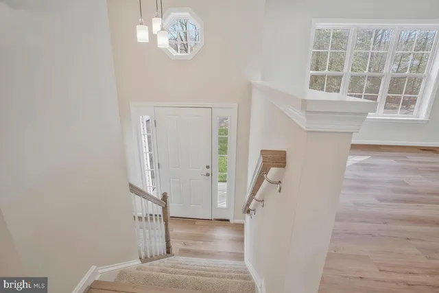 a view of a livingroom with wooden floor and stairs