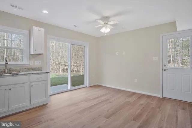 a view of a kitchen with a sink dishwasher and wooden floor