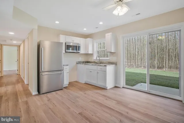 a kitchen with a refrigerator a sink and cabinets