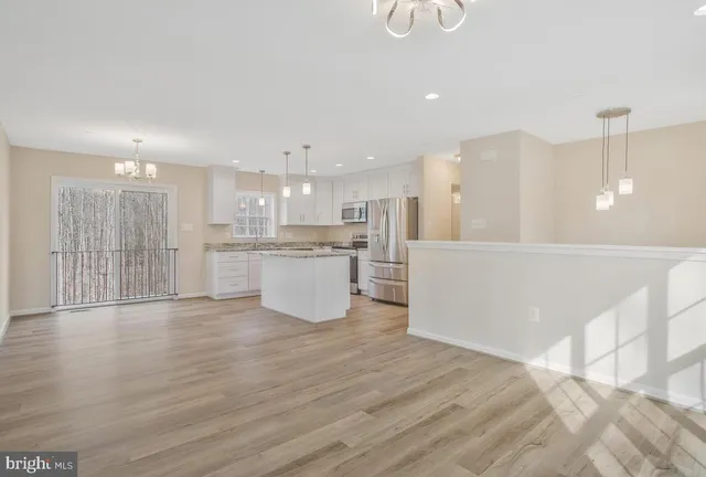 a view of kitchen with kitchen island wooden floor and center island