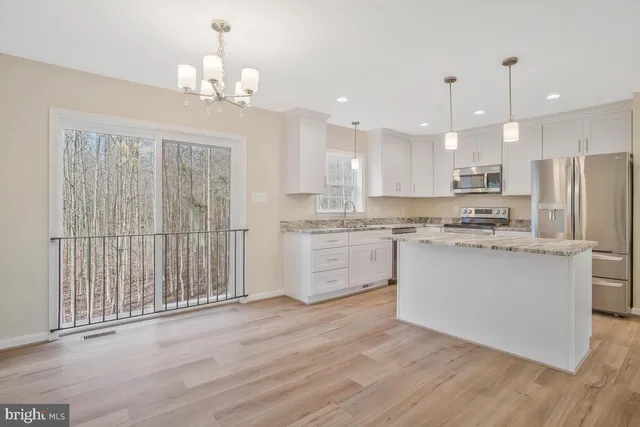 a kitchen with a refrigerator sink and cabinets