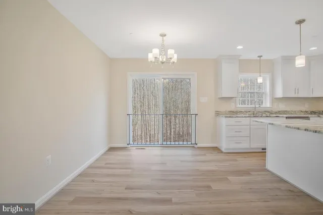 a view of kitchen with granite countertop cabinets and wooden floor