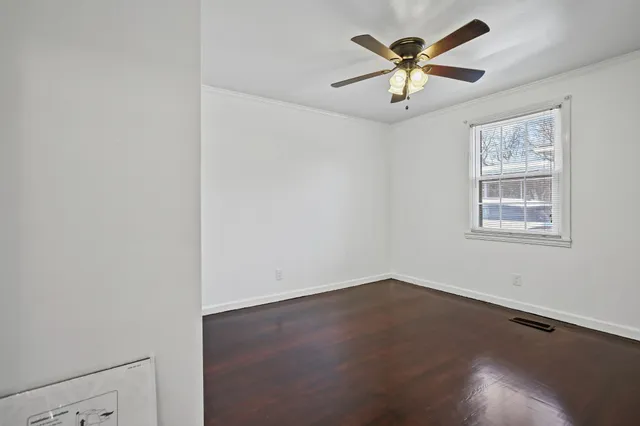 an empty room with a window and a ceiling fan