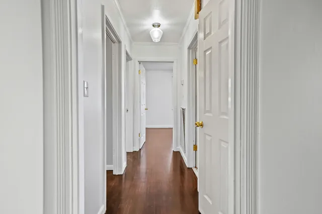 a view of a hallway with wooden floor and stair