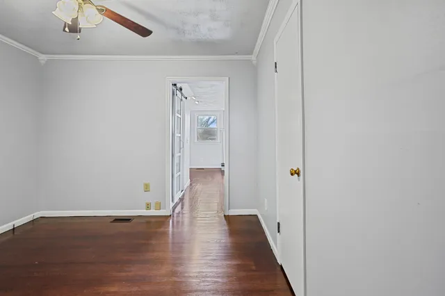 a view of an empty room with wooden floor