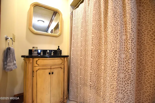 a bathroom with a mirror and a shower curtain