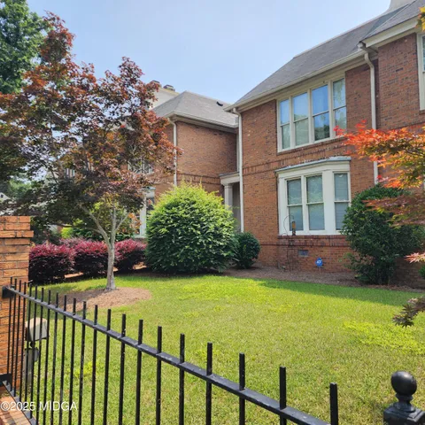 a view of an house with backyard and a tree