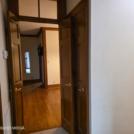 a view of a room with wooden floor and chandelier