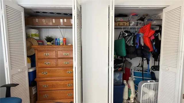 a view of walk in closet with clothes and shoes