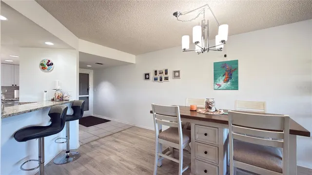 a kitchen with a dining table chairs cabinets and stainless steel appliances