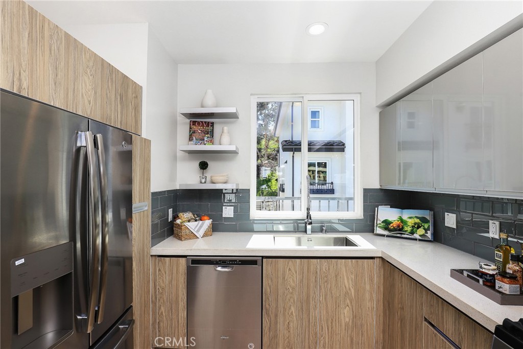 32 Spyglass Avenue Phillips Ranch, CA 91766 - Photo 16 of 63 a kitchen with stainless steel appliances a sink a refrigerator and a counter space