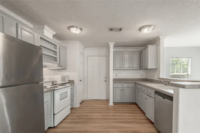 a kitchen with stainless steel appliances granite countertop a sink and a refrigerator