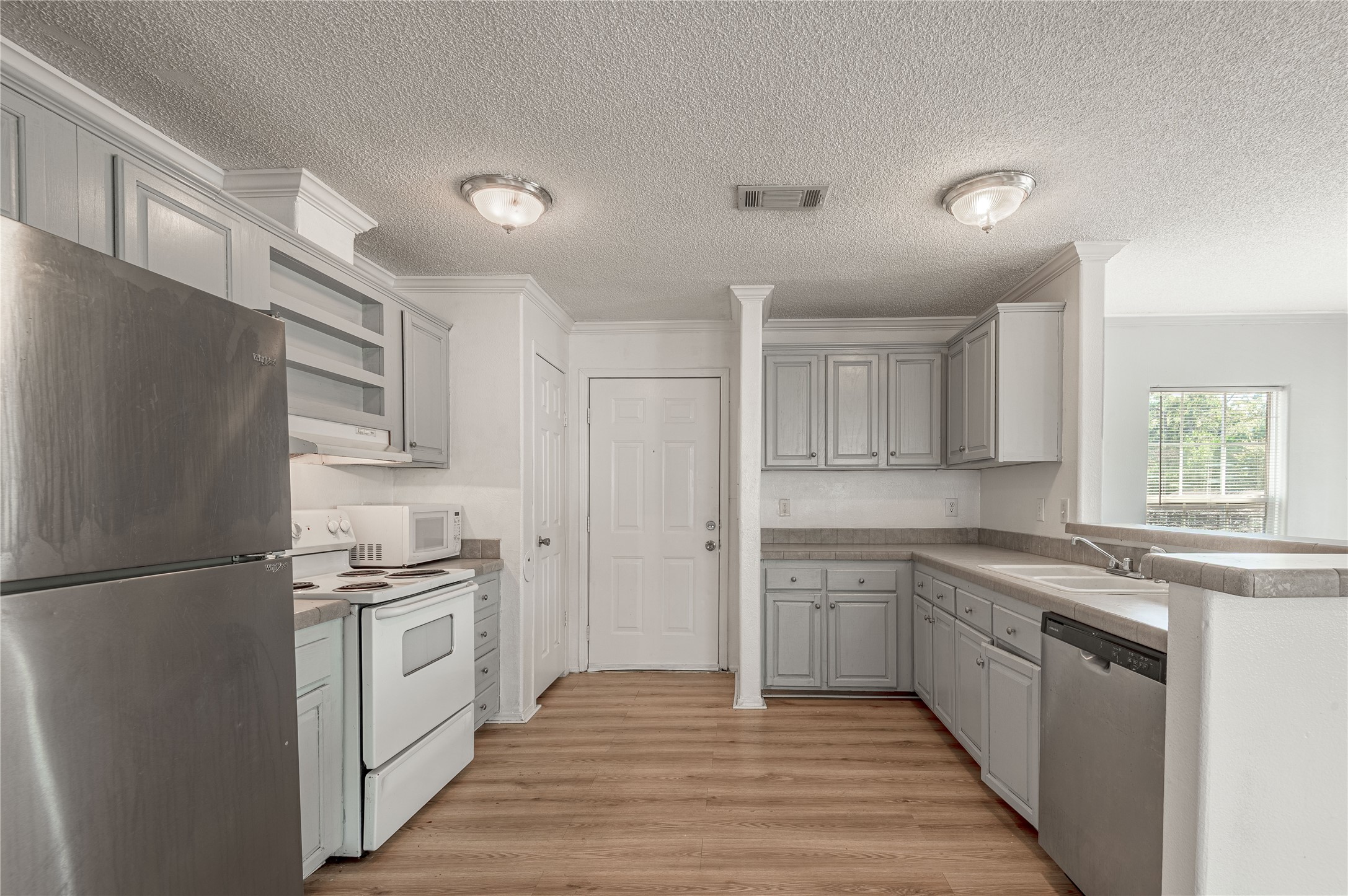112 Varsity Circle Huntsville, TX 77340 - Photo 11 of 33 a kitchen with stainless steel appliances granite countertop a sink and a refrigerator