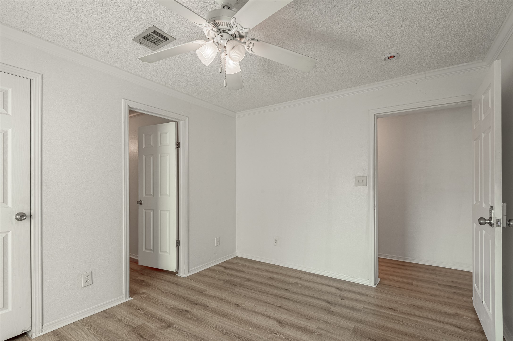112 Varsity Circle Huntsville, TX 77340 - Photo 19 of 33 an empty room with wooden floor fan and windows