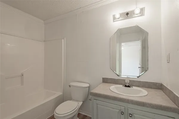a bathroom with a granite countertop sink toilet a mirror and shower