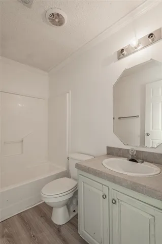 an empty room with wooden floor chandelier fan and windows