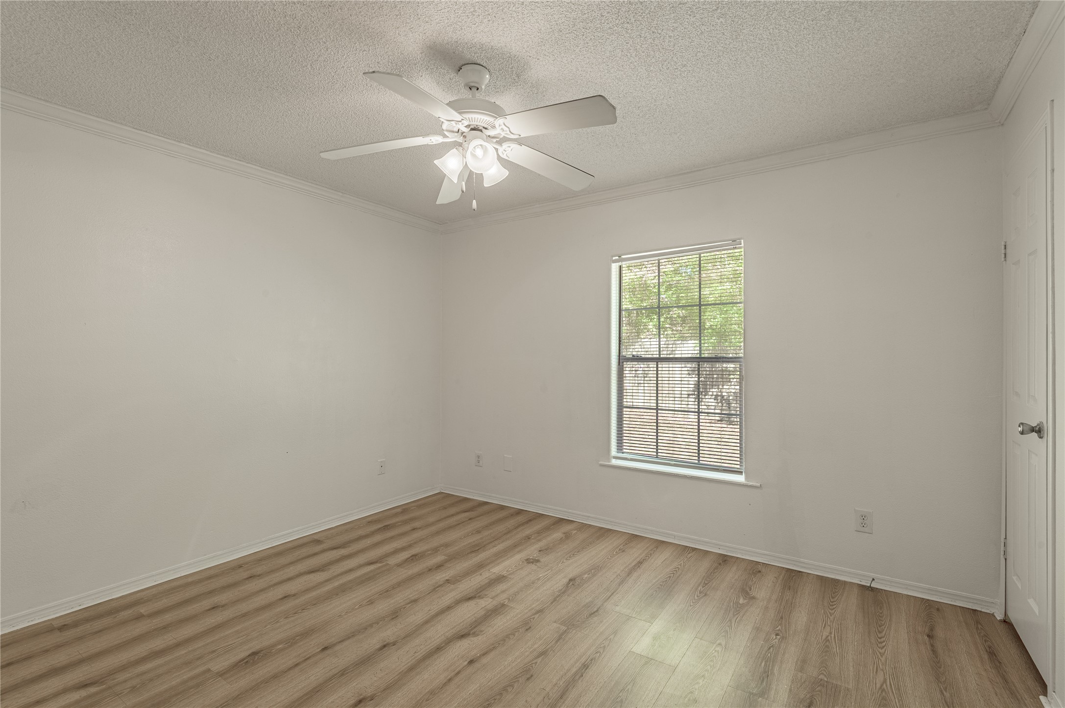112 Varsity Circle Huntsville, TX 77340 - Photo 25 of 33 an empty room with wooden floor chandelier fan and windows