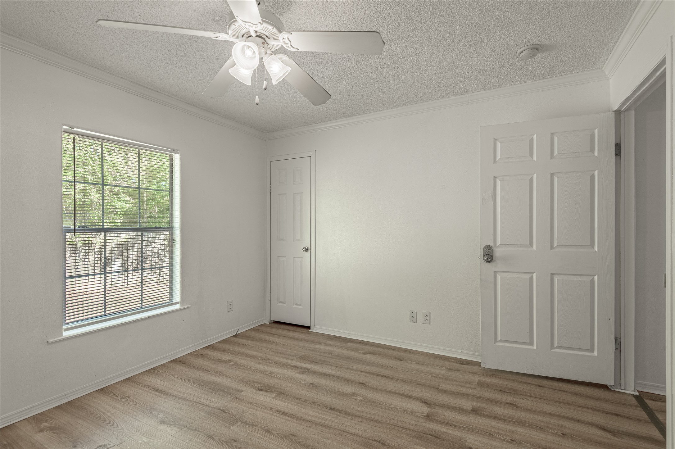112 Varsity Circle Huntsville, TX 77340 - Photo 27 of 33 an empty room with wooden floor chandelier fan and windows