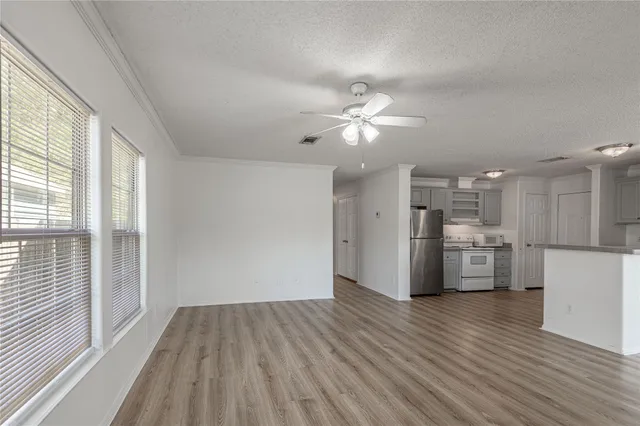 a view of a kitchen with refrigerator and wooden floor