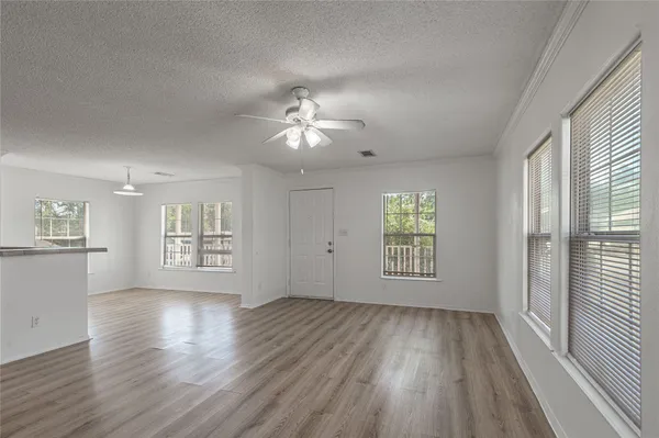 an empty room with wooden floor and windows