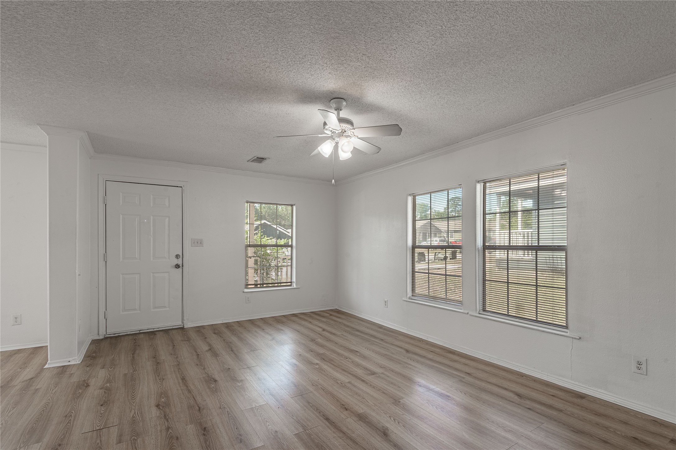 112 Varsity Circle Huntsville, TX 77340 - Photo 7 of 33 a view of an empty room with a window and wooden floor