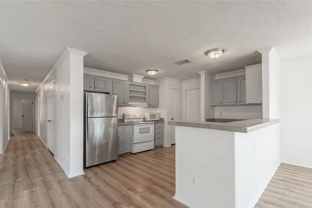 a kitchen with stainless steel appliances a refrigerator and a stove top oven