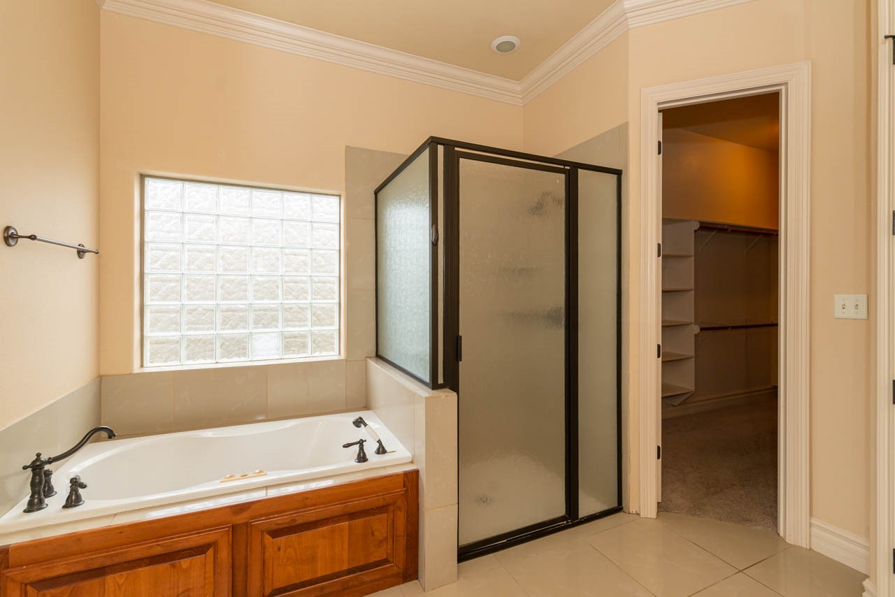 7 Stonebrook Court Beaumont, TX 77706 - Photo 14 of 35 a bathroom with a tub a sink and a window