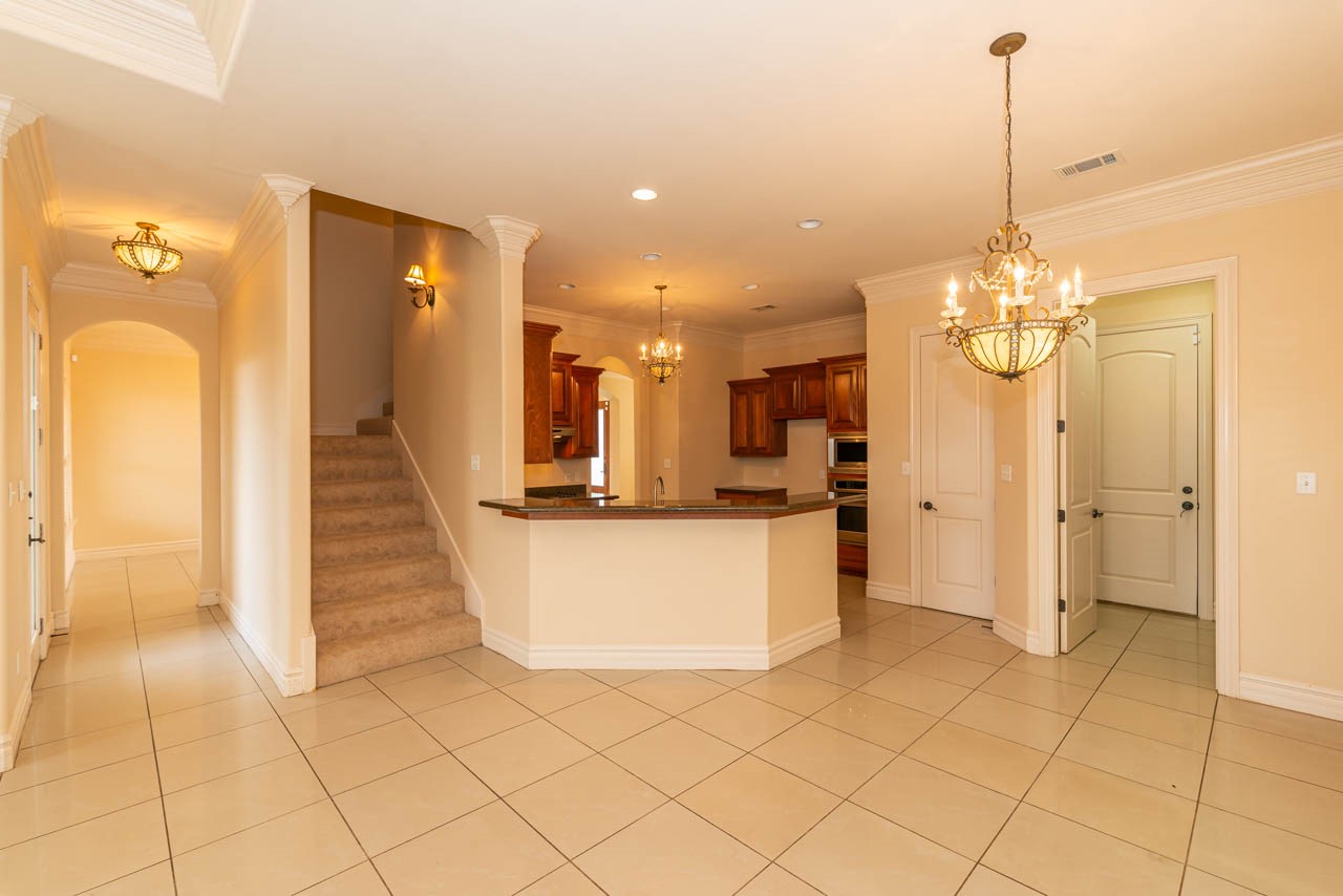 7 Stonebrook Court Beaumont, TX 77706 - Photo 20 of 35 a view of a kitchen with granite countertop a rug a stove and a chandelier