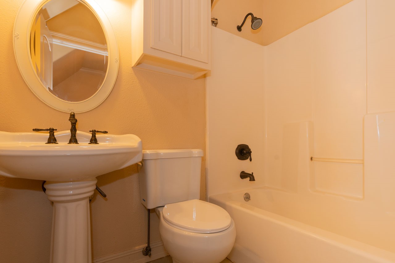 7 Stonebrook Court Beaumont, TX 77706 - Photo 28 of 35 a bathroom with a sink a mirror a toilet and a mirror