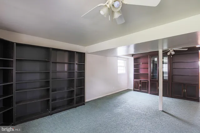a view of an empty room with a cabinet and a window