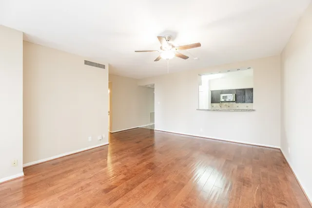 a view of an empty room with wooden floor