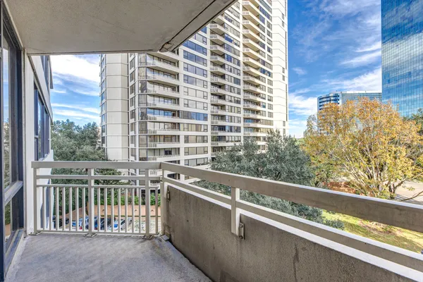 a view of balcony with a couple of cars parked in front of it