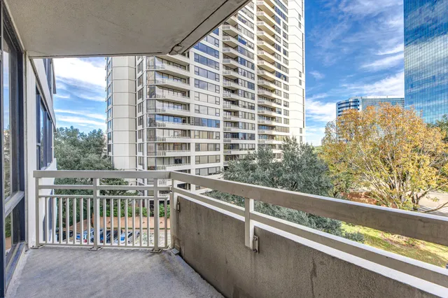 a view of balcony with a couple of cars parked in front of it