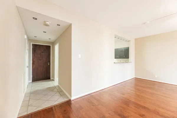 a view of an empty room with wooden floor