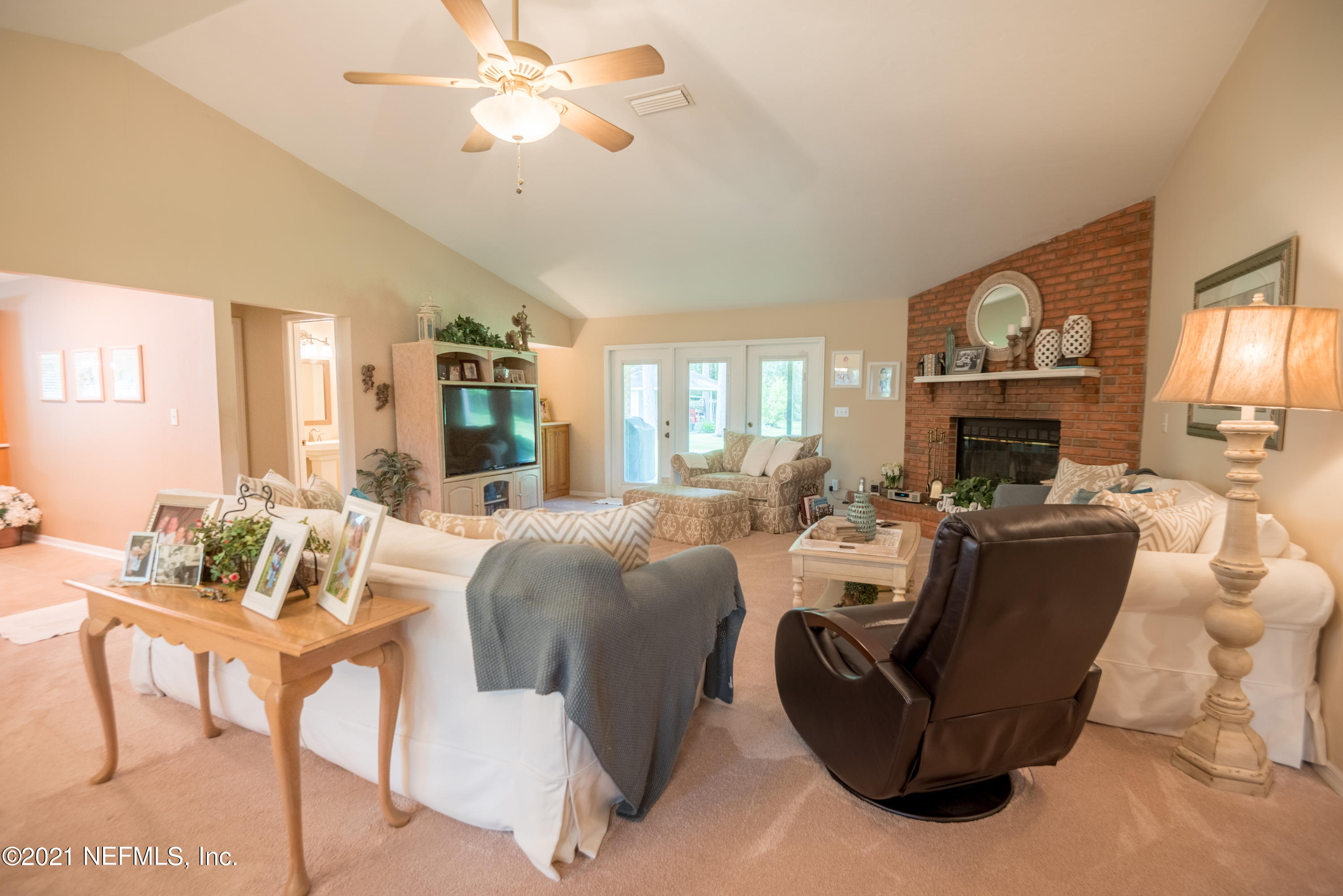 5200 Northwest 180th Way Starke, FL 32091 - Photo 8 of 83 a living room with furniture a fireplace and a chandelier