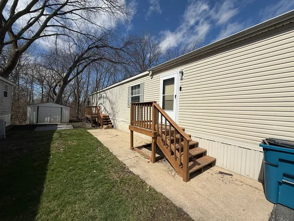 a view of a house with backyard and a trees