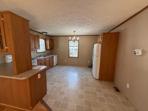 a view of kitchen with windows and refrigerator