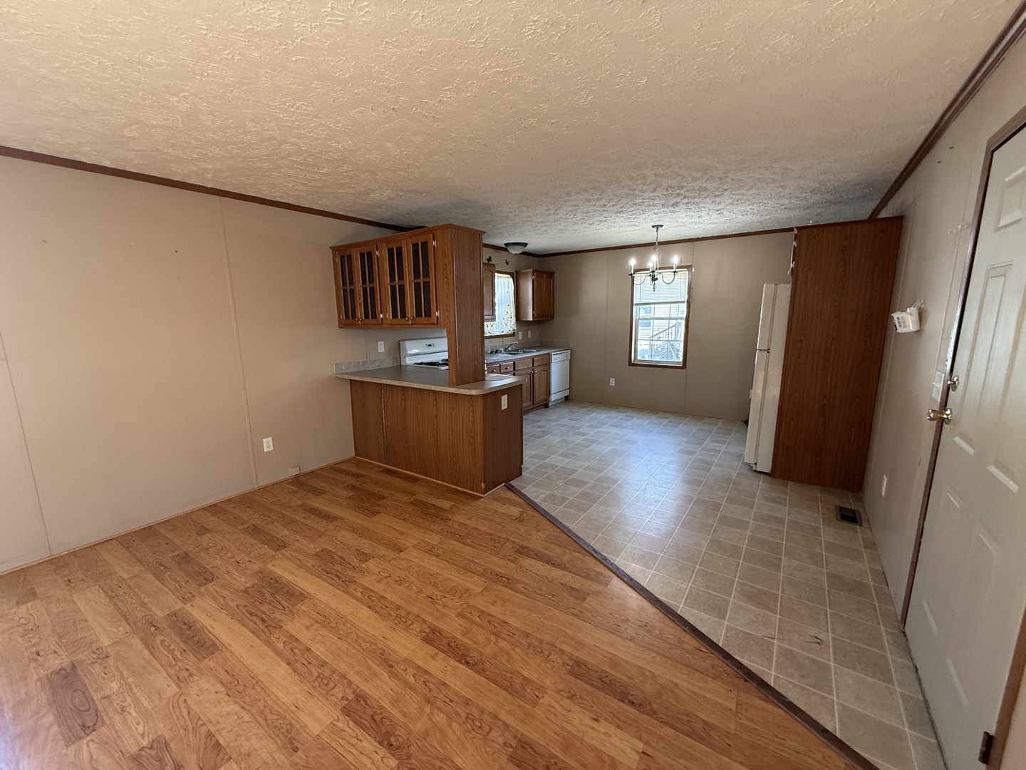 1712 South Dixie Highway, Unit 248 Crete, IL 60417 - Photo 10 of 19 a view of kitchen and empty room with wooden floor and window