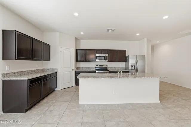 a large kitchen with stainless steel appliances granite countertop a stove and a sink