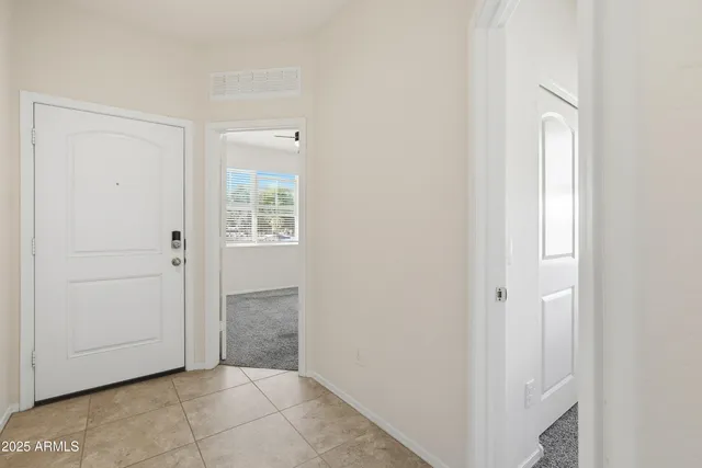a view of an empty room with closet and a window