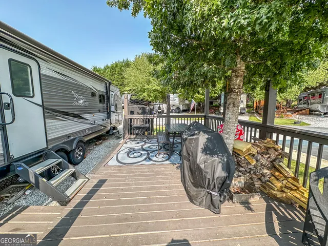 a view of a patio with table and chairs and potted plants with wooden floor and fence