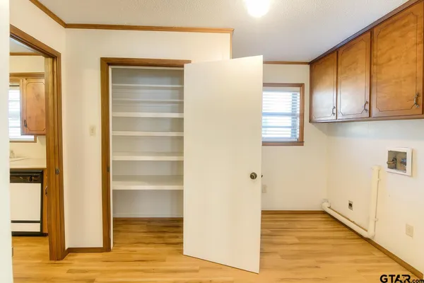 a view of empty room with wooden floor and cabinets