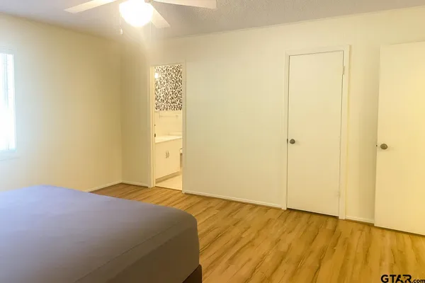 a bedroom with a bed and wooden floor