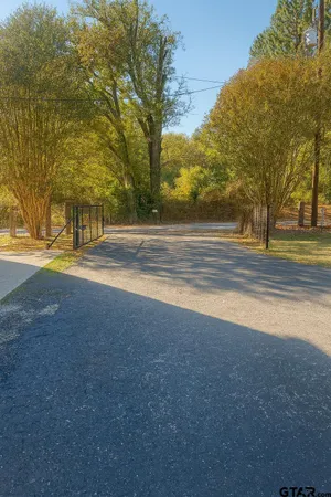 a view of a house with a big yard and large trees