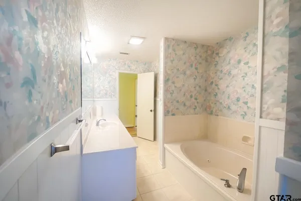a bathroom with a tub a sink and a shower curtain