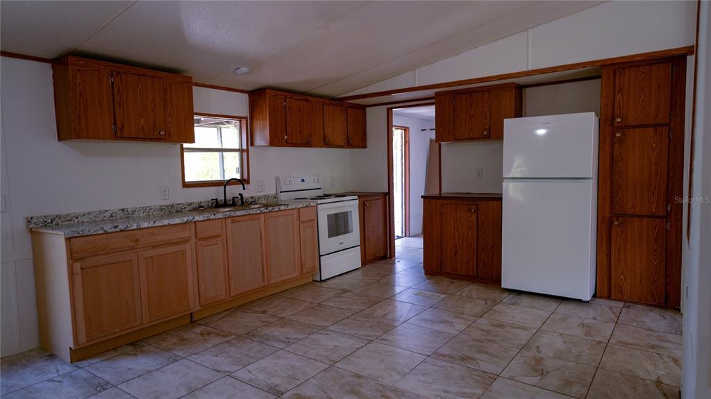 1550 East Orlando Road Orlando, FL 32820 - Photo 13 of 27 a kitchen with stainless steel appliances granite countertop a refrigerator and a sink