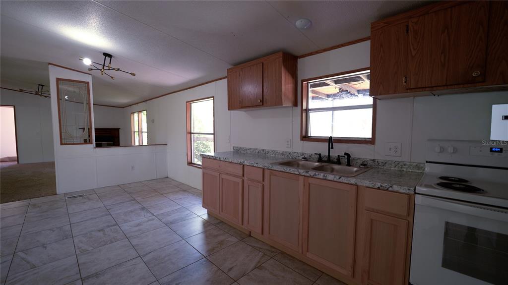 1550 East Orlando Road Orlando, FL 32820 - Photo 16 of 27 a kitchen with stainless steel appliances granite countertop a sink stove and cabinets