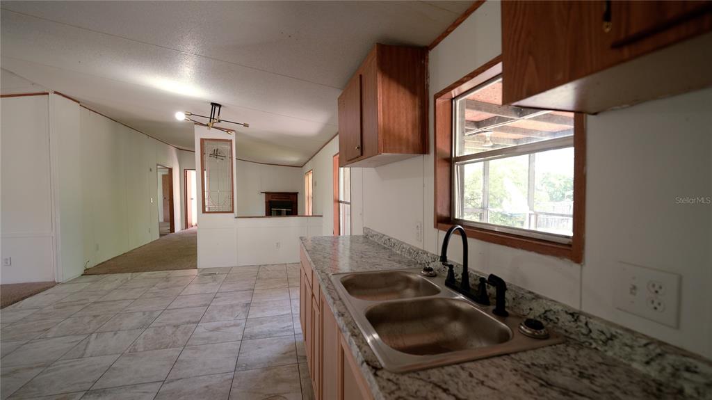 1550 East Orlando Road Orlando, FL 32820 - Photo 17 of 27 a kitchen with a sink a stove and a window