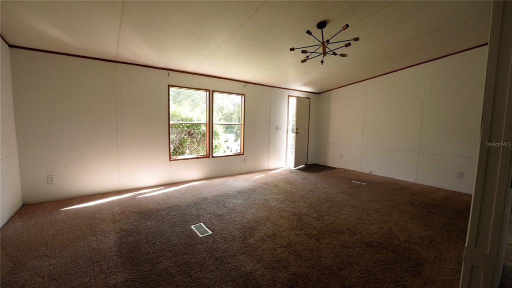 1550 East Orlando Road Orlando, FL 32820 - Photo 18 of 27 an empty room with windows and ceiling fan